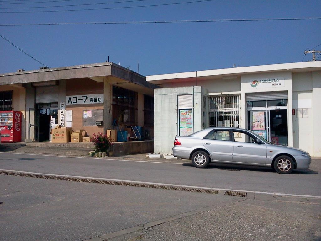 並んで建っている茶色の建物のAコープ粟国支店と白色の建物のJAおきなわ粟国支店の外観の写真